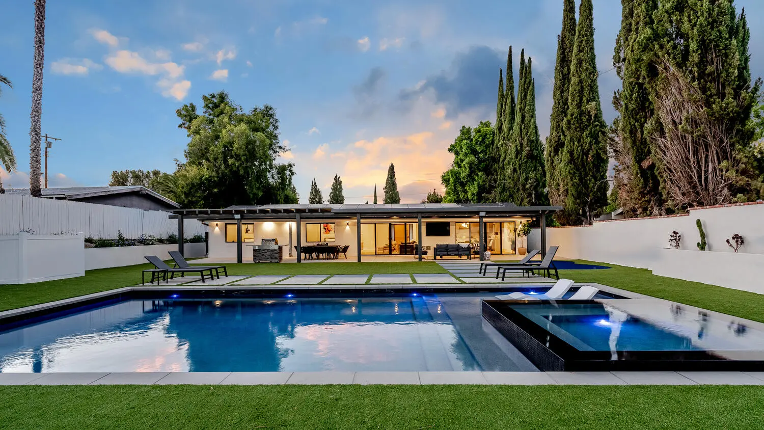 Modern vacation home with pool and evening sky